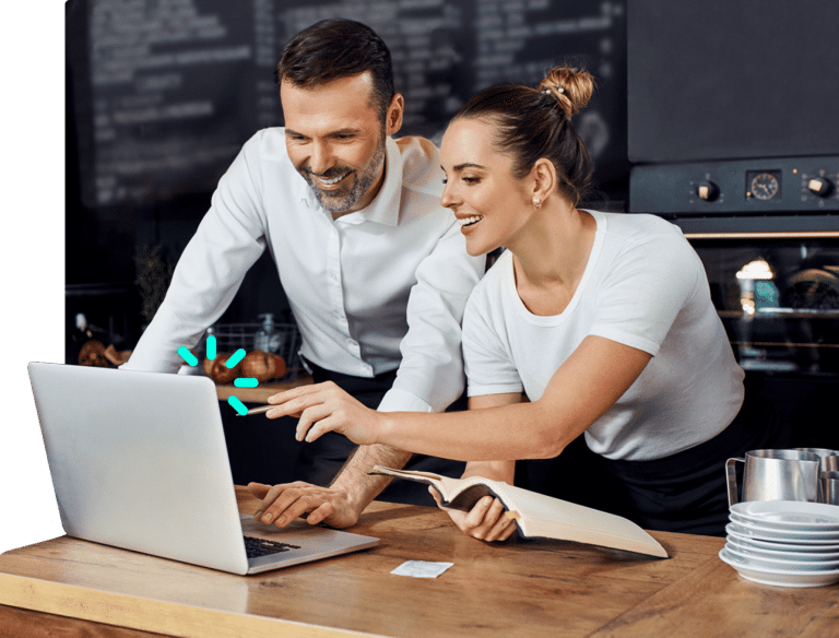 Two managers of a restaurant smiling, looking at the Olaclick's point of sale system