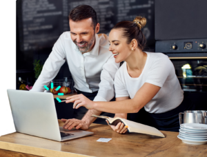 Dos Managers de un restaurante sonriendo mirando al sistema de punto de venta de Olaclick