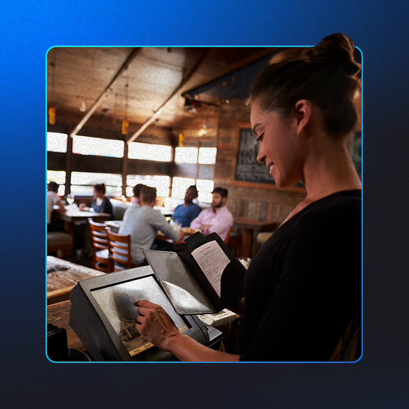 foto de uma atendente de restaurante gerenciando pedidos no sistema de pdv completo, por meio de um monitor