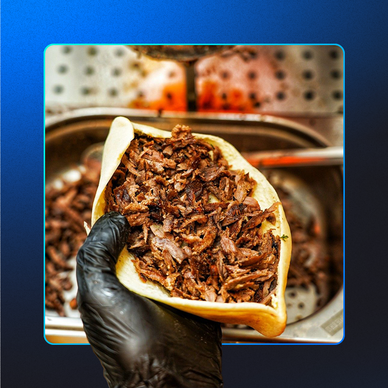 foto de um churrasqueiro montando um lanche de churrasco grego