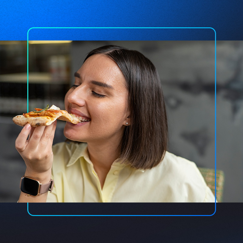 foto de uma mulher mordendo um pedaço de pizza depois de escolher do cardapio de pizzaria