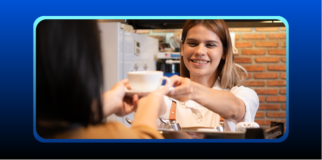 foto de uma garçonete de franquia de cafeteria sorridente entregando uma xícara de café a uma cliente