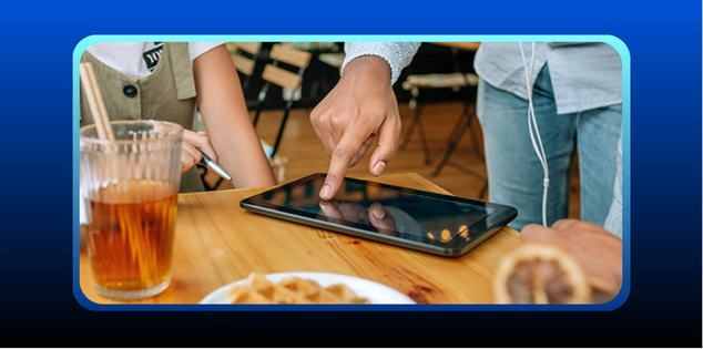 foto em lanchonete com zoom na mesa de um cliente onde um tablet com gestor de pedidos ifood está aberto e o atendente está gerenciando